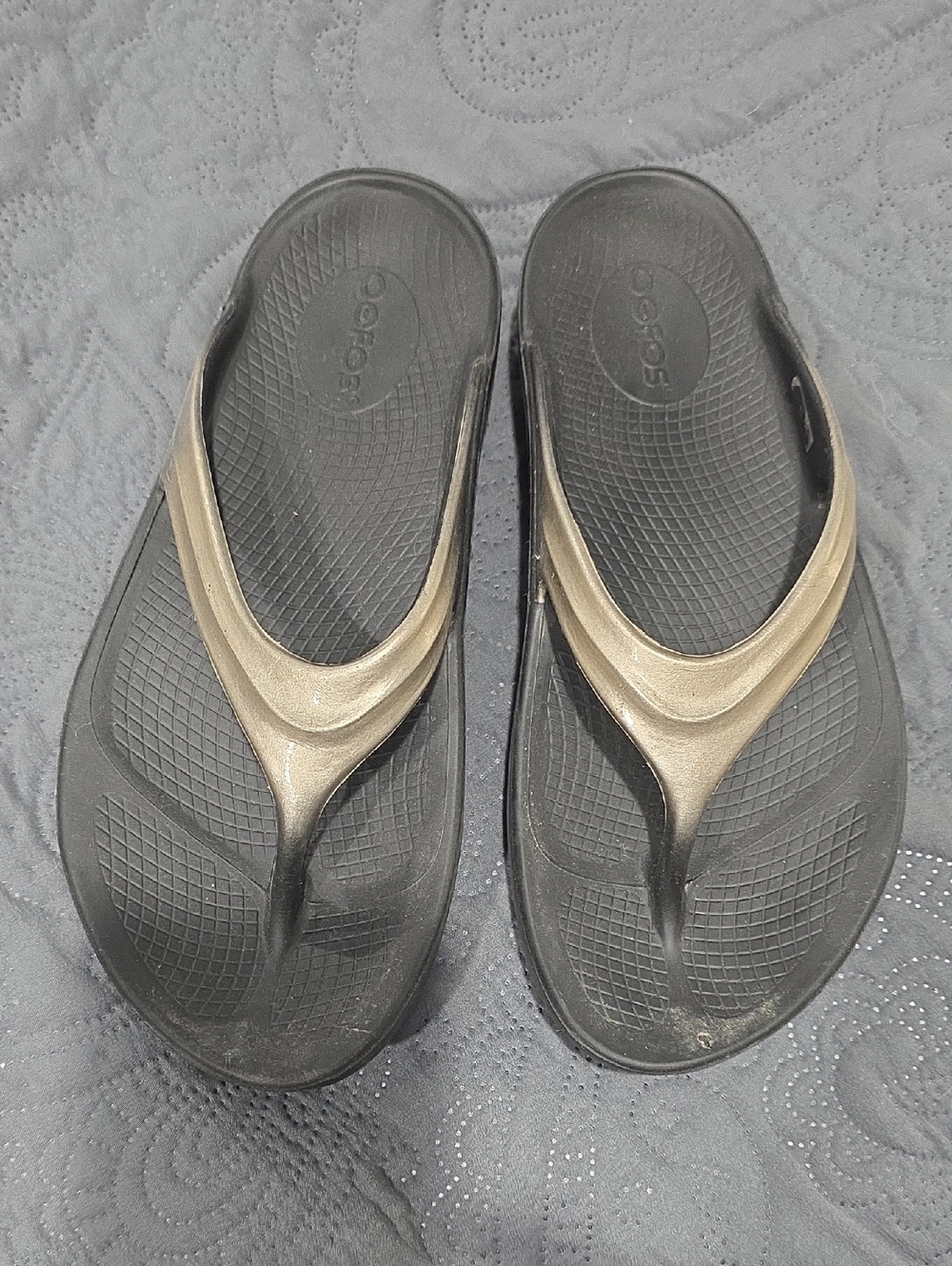 OOFOS Women's Flip Sandals in Black with Metallic Gold Straps